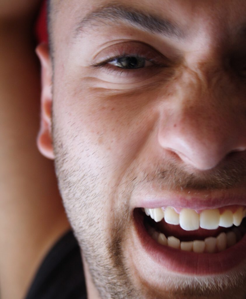Ein Mann öffnet seinen Mund weit und zeigt damit seine schönen Zähne.